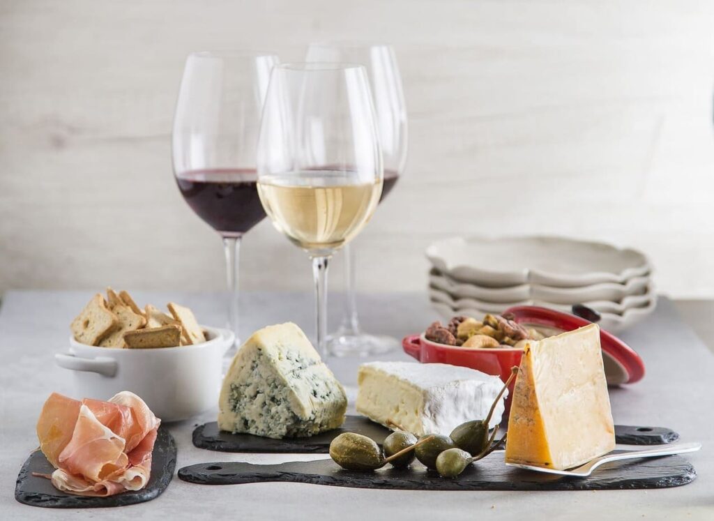 seleção de vinhos brancos e tintos harmonizados com queijos e frios