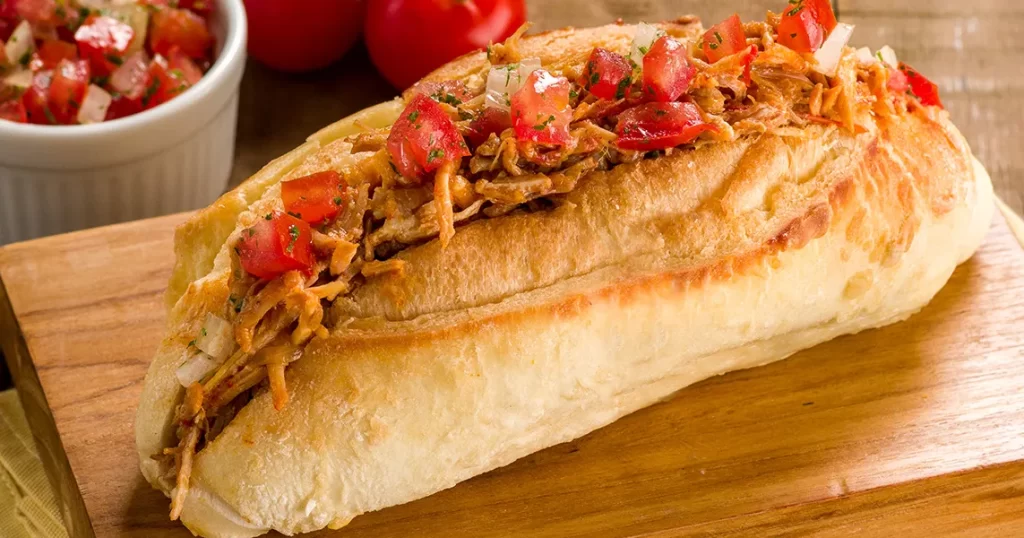sanduíche com pernil e vinagrete para comemorar o dia do pão francês